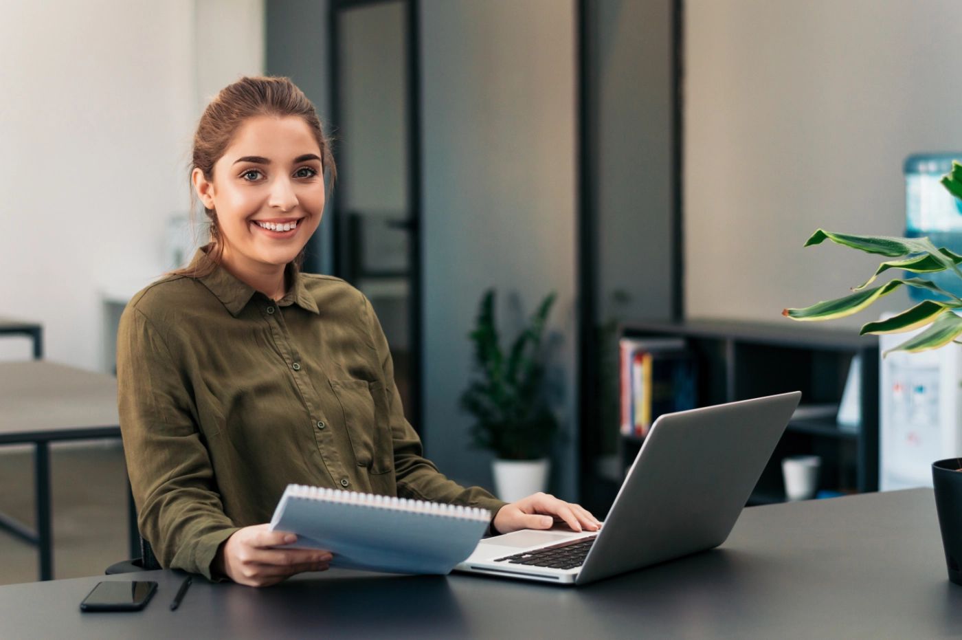 Young professional woman sitting at a desk with a laptop computer.